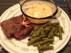 Half of my New York Strip with some scalloped potatoes and green beans
